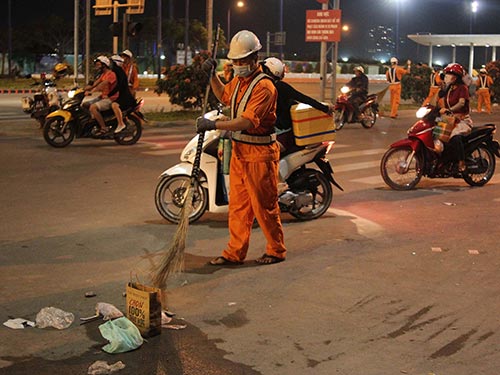 Hằng ngày, công nhân vệ sinh luôn vất vả dọn rác trên đường Mai Chí Thọ (quận 2, TP HCM). Ảnh: HOÀNG TRIỀU