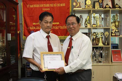
Ông Tạ Long Hỷ (phải), Phó Tổng Giám đốc Công ty Vinasun, tặng giấy khen và tiền thưởng cho tài xế Đặng Xuân Trà
