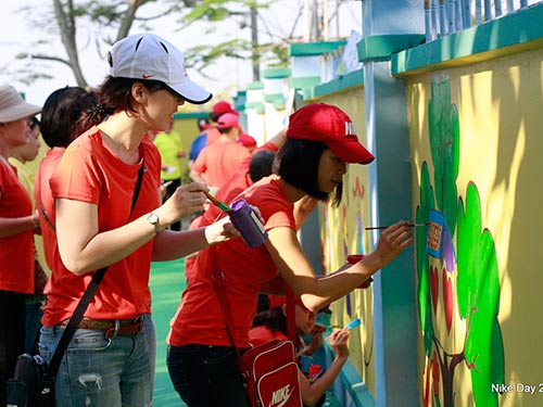 Nhân viên Công ty TNHH Nike Việt Nam tham gia sơn tường mới cho Trường Tiểu học Lê Quang Định