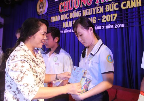 Bà Trần Kim Yến, Chủ tịch LĐLĐ TP HCM, trao học bổng cho con CNVC-LĐ Ảnh: HOÀNG TRIỀU