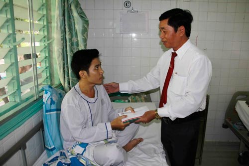 Ông Nguyễn Hữu Dũng, Chủ tịch Công đoàn Vinasun, trao tiền hỗ trợ cho anh Nguyễn Quốc Bửu
