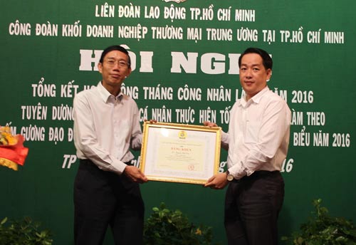 Ông Kiều Ngọc Vũ, Phó Chủ tịch LĐLĐ TP HCM (phải), tặng bằng khen cho đại diện doanh nghiệp chăm lo tốt cho người lao động