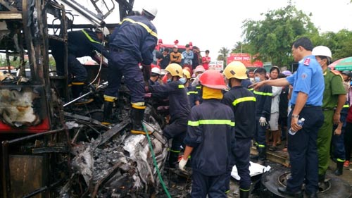 Lực lượng cứu hộ đưa thi thể các nạn nhân ra khỏi 2 chiếc xe khách bị cháy Ảnh: hoàng THái