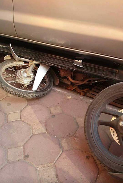 Chiếc xe máy nằm lọt trong gầm ô tô...