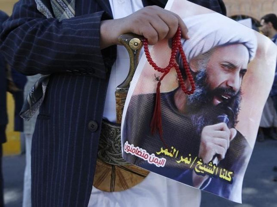 Người biểu tình cầm di ảnh của giáo sĩ nổi tiếng Nimr al-Nimr. Ảnh: Reuters