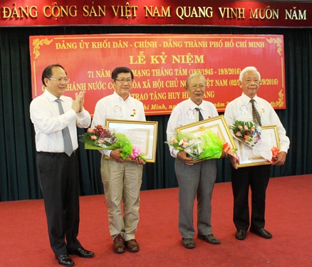 
Ông Tất Thành Cang, Phó Bí thư Thường trực Thành ủy TP HCM trao huy hiệu tuổi đảng cho các đảng viên
