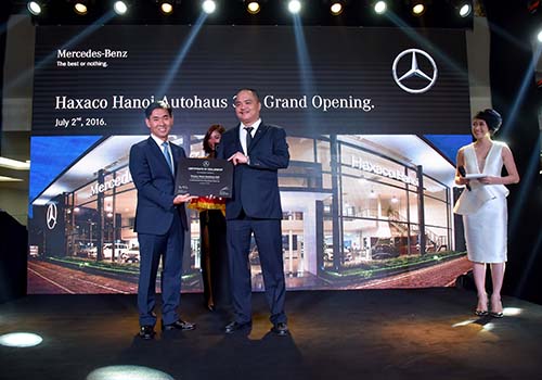 Ông Choi Duk Jun (trái), Giám đốc điều hành xe du lịch Mercedes-Benz Việt Nam, trao bằng chứng nhận cho Haxaco Hà Nội