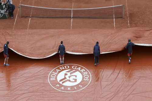 Nhân viên sân Roland Garros kéo bạt chống thấm mặt sân