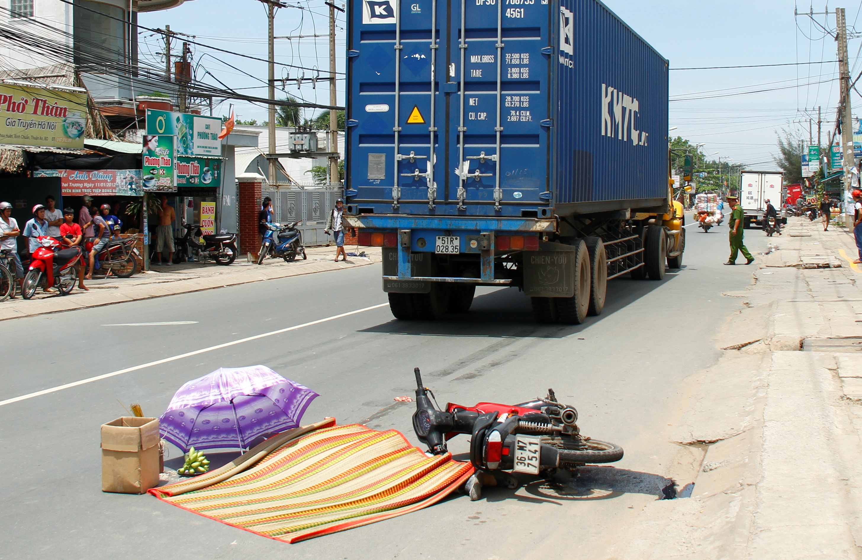 Thi thể ông Ngọ được đắp chiếu che dù trên đường phố