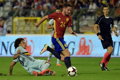 Saul Niguez tranh chấp bóng với Axel Witsel (trái)