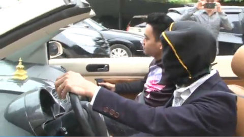 
Người đàn ông điều khiển xe Volkswagen khi đang trùm kín khăn đen trên đầu (ảnh cắt ra từ clip)
