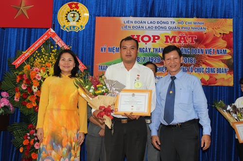 Lãnh đạo LĐLĐ TP HCM và Quận ủy Phú Nhuận trao kỷ niệm chương và tặng hoa chúc mừng các cá nhân có cống hiến cho tổ chức Công đoàn Ảnh: Thanh Nga
