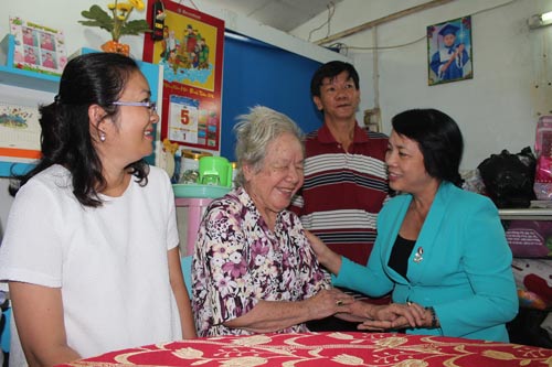 Bà Trần Kim Yến (bìa phải), Chủ tịch LĐLĐ TP HCM, hỏi thăm sức khỏe cụ Huỳnh Thị Dung