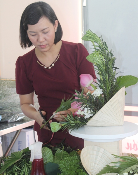 
Cô Thúy Oanh huớng dẫn sinh viên một kiểu cắm hoa độc đáo - hoa sen trên nón lá
