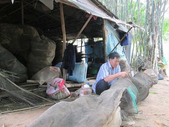 
Anh Buôl bên những chiếc đú chưa đặt được vì nước lũ quá thấp. Ảnh: TRỌNG BÌNH
