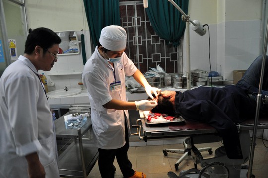 Ông Trần Anh Tuấn đang được các bác sĩ cấp cứu sau khi bị nhóm thanh niên chém trọng thương