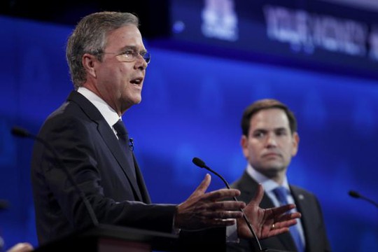Thượng nghị sĩ Marco Rubio (phải) nhìn ông Jeb Bush phát biểu tối 28-10. Reuters
