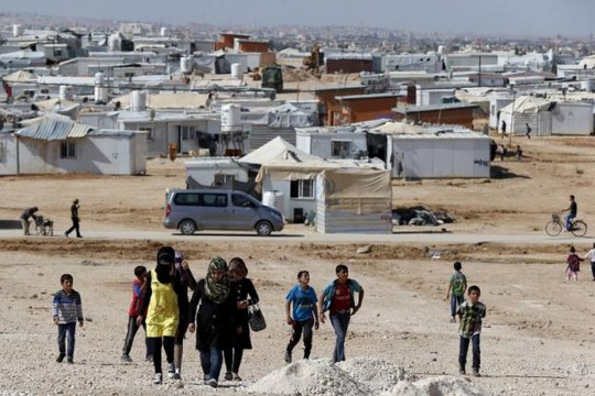 Người tị nạn Syria đi bộ ở trại tị nạn Al Zaatari, TP Mafraq - Jordan, gần biên giới Syria hôm 1-11. Ảnh: Reuters