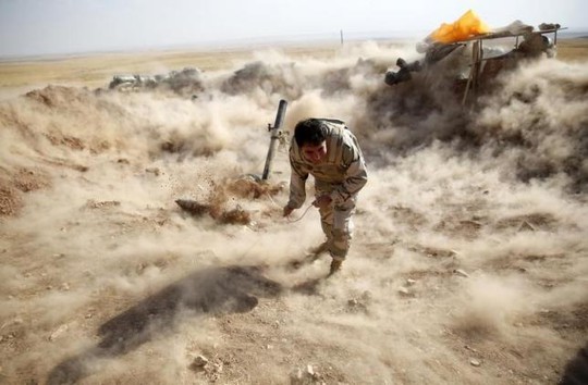 Một chiến binh người Kurd bắn đạn cối về phía Zummar, khu vực IS kiểm soát gần TP Mosul. Ảnh: Reuters