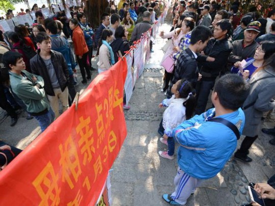 Những người đàn ông nông thôn Trung Quốc đang cùng cha mẹ đến xem quảng cáo môi giới hôn nhân ở Nam Kinh - Ảnh: news.com.au 