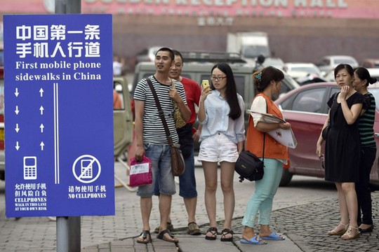 
Một làn đường dành riêng cho những người vừa đi bộ dán mắt vào smartphone ở Trùng Khánh, Trung Quốc. Ảnh: TWP.
