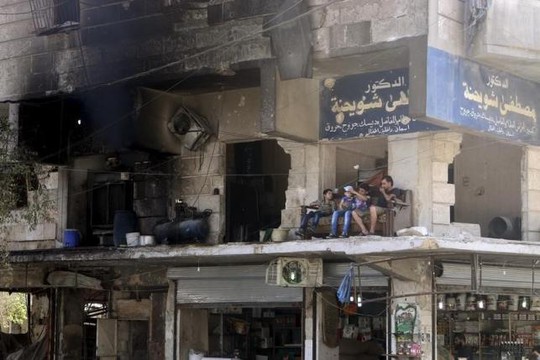 Người dân Syria giữa cảnh hoang tàn ở TP Aleppo hồi đầu tháng 8-2015. Ảnh: Reuters