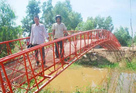 Ông Ba Đạt (người đứng phía trước) giới thiệu chiếc cầu đáy dày do ông vừa thi công ở xã Bình Sơn, huyện Hòn Đất, tỉnh Kiên Giang