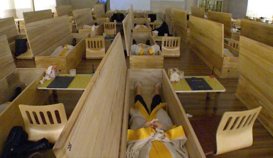 
Các nhân viên Hàn Quốc nằm vào quan tài trong đám tang của chính mình để suy ngẫm về giá trị cuộc sống Ảnh: BBC
