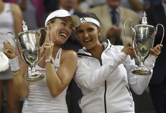 Mirza (phải) và Hingis nhận cúp vô địch đôi nữ Wimbledon rạng sáng 12-7  Ảnh: REUTERS