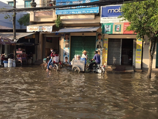 
Nước ngập đầy đường, tràn cả vào nhà dân, gây khó khăn cho việc mua bán, sinh hoạt.

