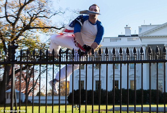 Người đàn ông mặc chiếc áo bóng chày, đeo găng tay, quấn một lá cờ Mỹ trên người và hai hàm răng cắn chặt một chiếc bìa đựng tài liệu. Ảnh: Daily Mail
