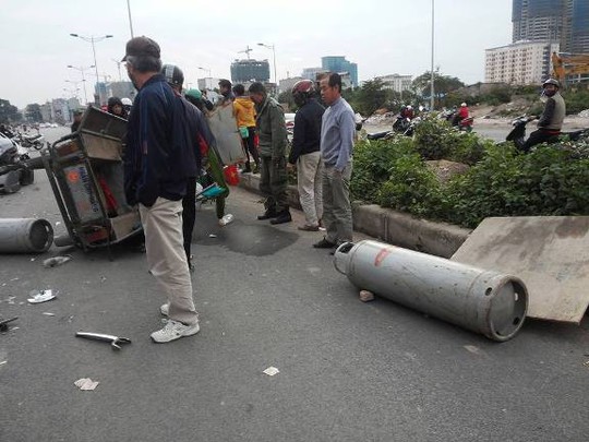 Chiếc xe thương binh 3 bánh đổ ra đường và bị hư hỏng nặng sau vụ tai nạn, các bình gas lăn lóc cạnh đó