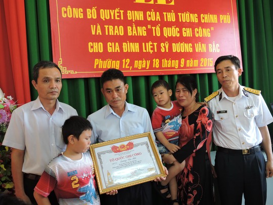
Người chị cùng 2 con nhỏ của liệt sĩ Dương Văn Bắc trong lễ trao bằng Tổ quốc ghi công
