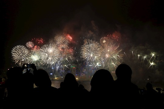 
Người dân Hồng Kông xem pháo hoa bắn trên Cảng Victoria. Ảnh: Reuters
