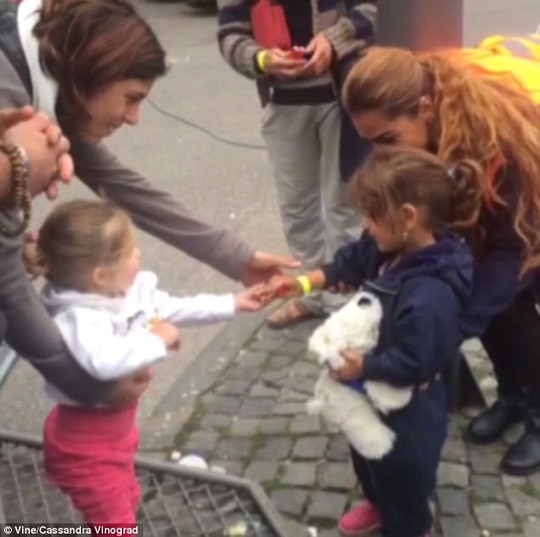 Bé gái người Đức chia bánh cho bé gái nhập cư. Ảnh: Vine