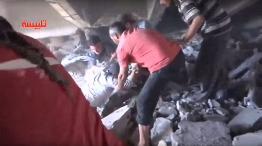 Người dân Syria giúp kéo các nạn nhân khỏi đống đổ nát sau cuộc không kích của Nga. Ảnh: Daily Mail