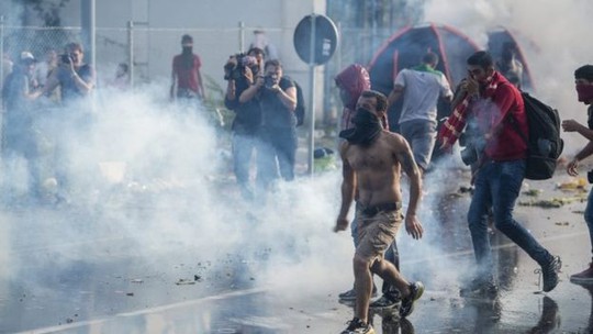 Người tị nạn bị cảnh sát chống bạo động Hungary bắn hơi cay và vòi rồng. Ảnh: EPA, AP