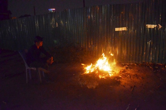 
Một bảo vệ công trường tại dốc Bưởi đốt củi sưởi ấm giữa đêm lạnh
