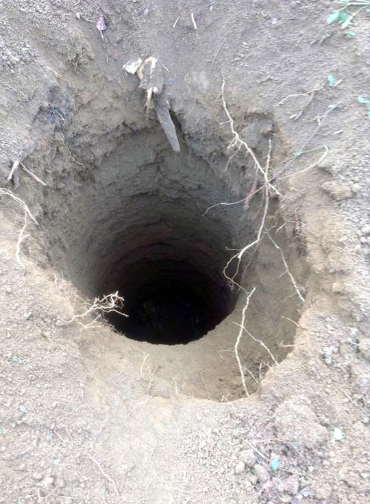 Nghi phạm Kiều Quốc Huy (x) và giếng sâu hơn 10 m, nơi y chôn xác vợ chồng nạn nhân
