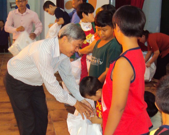 Ông Nguyễn Văn Dễ - Chủ tịch LĐLĐ quận Bình Tân, TP HCM - trao quà cho các em thiếu nhi Ảnh: CÔNG DANH