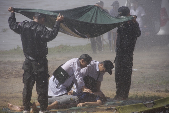 Lực lượng CSCĐ đứng che mưa để các bác sĩ sơ cứu người bị nạn khi bão đang đổ bộ