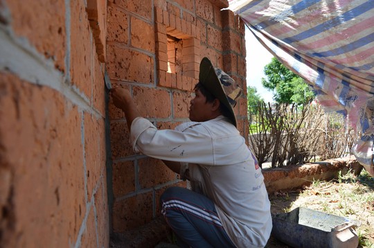 Thợ xây đang tô lại bức tường bọc bên ngoài khu lưu niệm xây bằng đá tổ ong