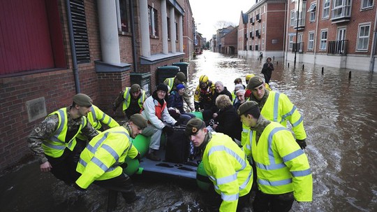 Nhân viên cứu hộ giúp người dân đến nơi sơ tán. Ảnh: Daily Mail