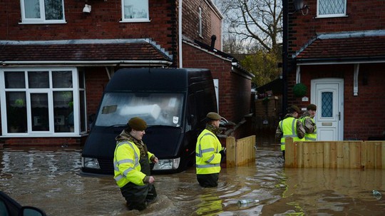 Nhân viên cứu hỗ giúp người dân sơ tán. Ảnh: Daily Mail