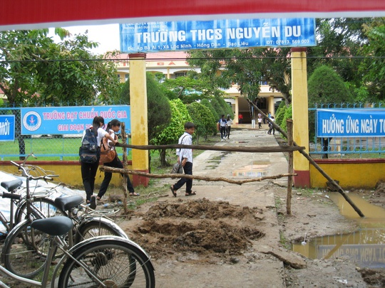 Các em HS Trường THCS Nguyễn Du phải chen qua hàng rào để vào trường học