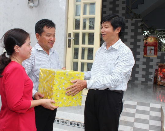 Ông Trịnh Thiện Trung - Phó Chủ tịch LĐLĐ huyện Nhà Bè, TP HCM (bìa phải) - trao quà cho gia đình anh Nguyễn Nam Hùng (nhân viên bảo vệ huyện ủy) tại lễ bàn giao Mái ấm Công đoàn Ảnh: THANH NGA