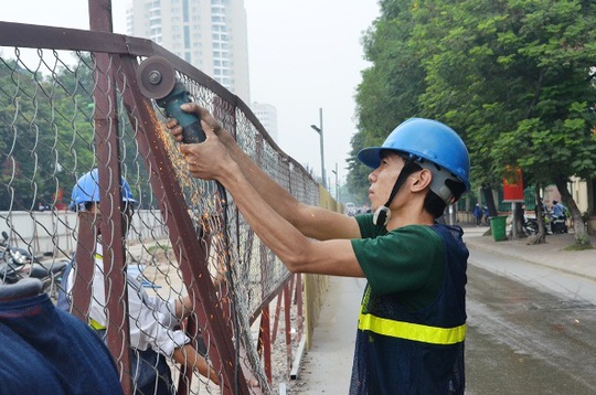 
Công nhân đang cắt bỏ hàng rào sắt của chiếc lô cốt trên đường Xuân Thủy
