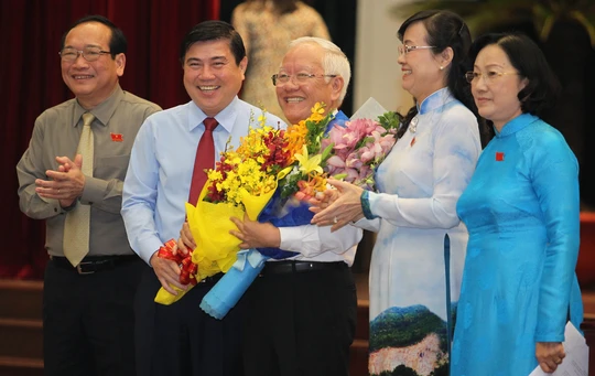 
Tân Chủ tịch UBND TP Nguyễn Thành Phong tặng hoa cho người tiền nhiệm Lê Hoàng Quân
