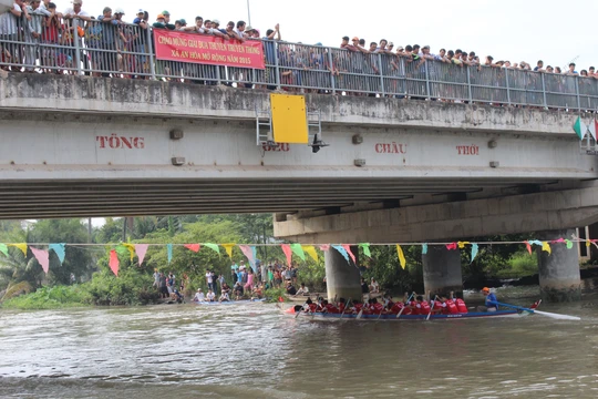 
Tiếng hò reo cổ vũ vang khắp con sông, đặc biệt là ở cây cầu sắt nhỏ lâu đời gắn liền đôi bờ
