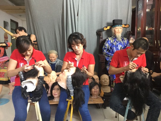 Các chuyên viên gắn tóc lên khuôn mặt các bức tượng nghệ sĩ